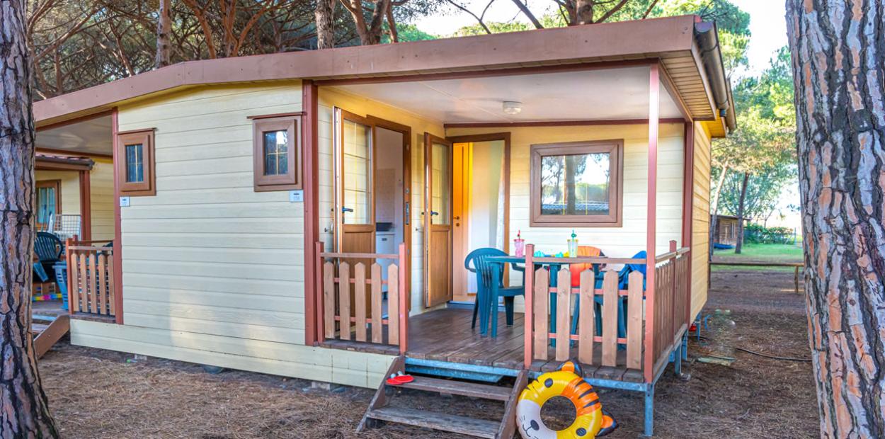 Bungalow in legno con veranda, immerso nella natura, ideale per vacanze rilassanti.