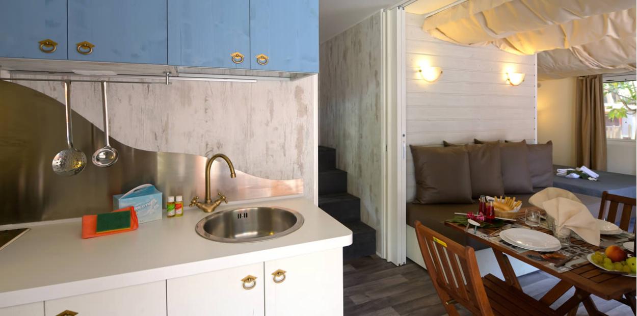 Cucina moderna con salotto accogliente e zona pranzo, arredi eleganti e funzionali.