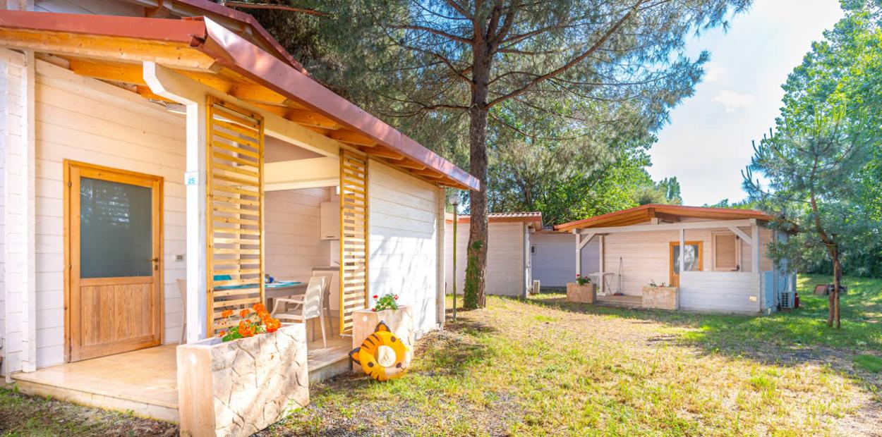 Bungalow in legno immersi nella natura, con terrazza e arredi semplici.