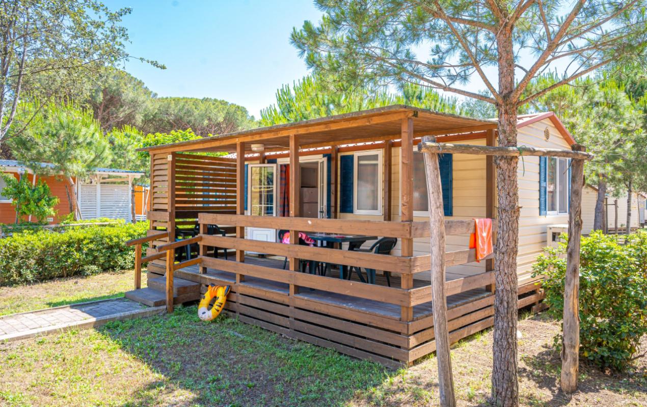 Bungalow in legno con veranda, immerso nella natura, ideale per vacanze rilassanti.