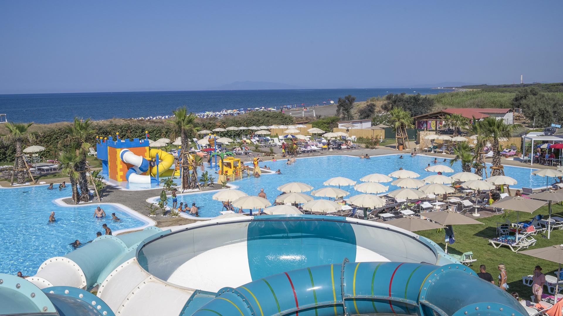 Parco acquatico con scivoli, piscine e area giochi per bambini vicino al mare.
