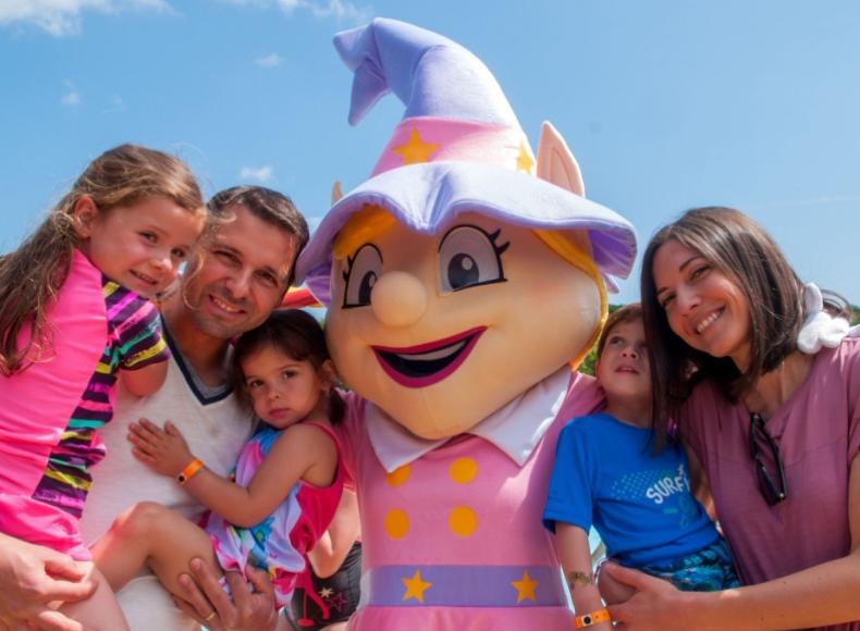 Famiglia felice con mascotte in costume colorato durante una giornata di sole.