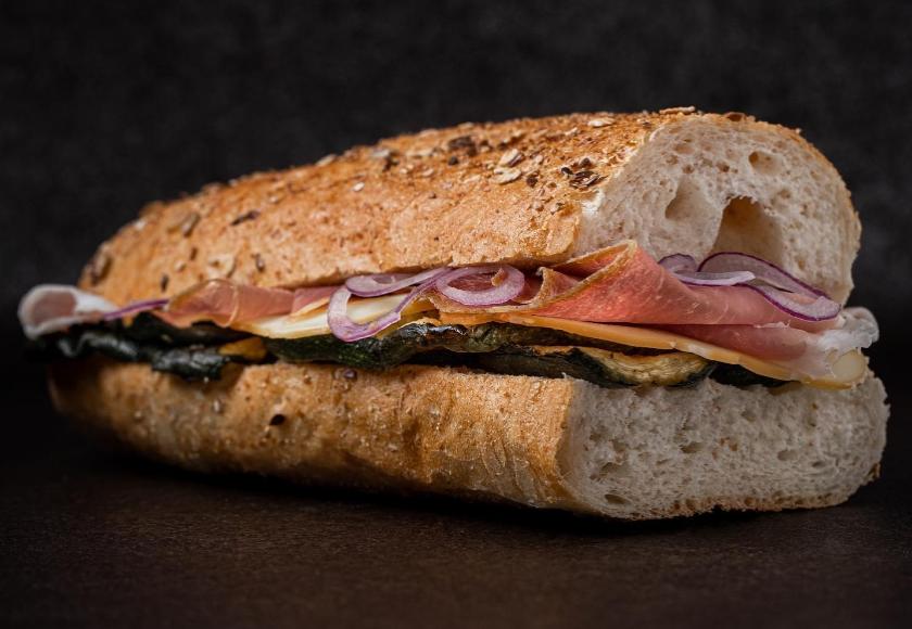 Panino con prosciutto crudo, formaggio, zucchine grigliate e cipolle rosse.